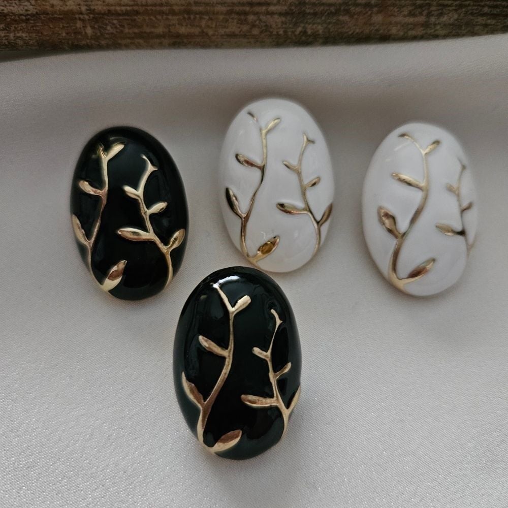 Siyah ve Beyaz Oval Küpe – Altın Dal Desenli Zarif Tasarım