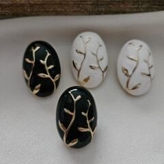 Siyah ve Beyaz Oval Küpe – Altın Dal Desenli Zarif Tasarım